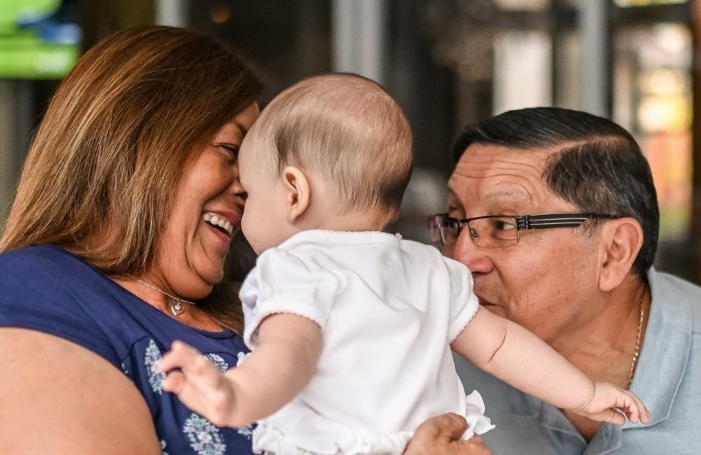 grandparents holding their grandchild
