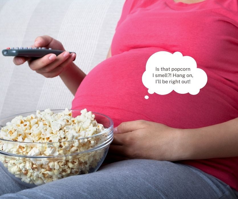 pregnant woman at 25 weeks with a bowl of popcorn