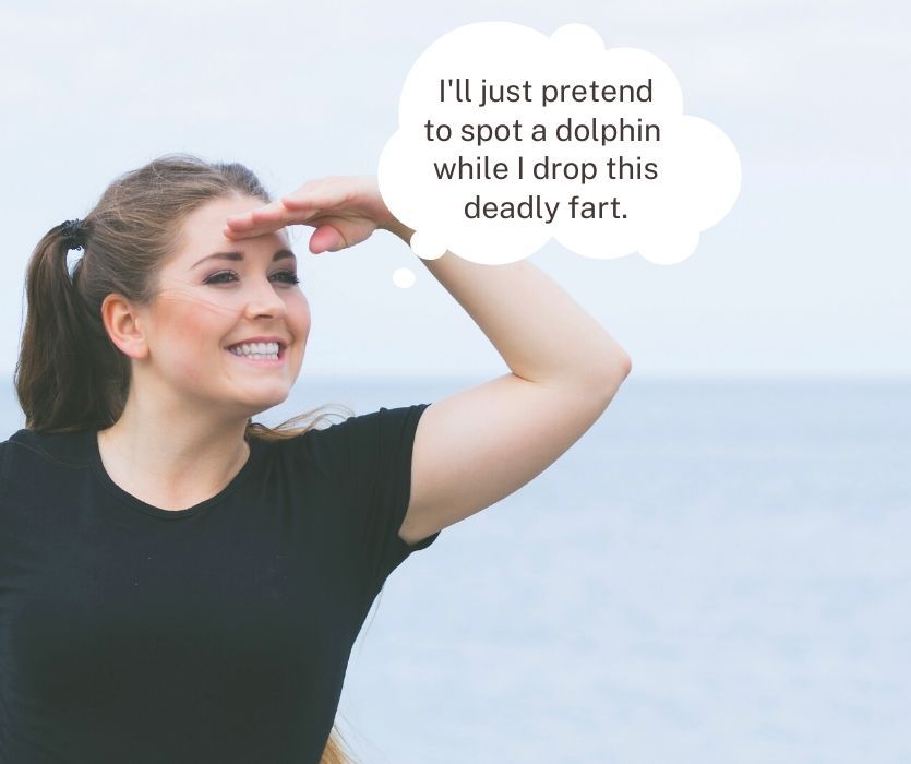 woman 8 weeks pregnant looking out to sea saying "I'll just pretend to spot a dolphin while I drop this deadly fart."