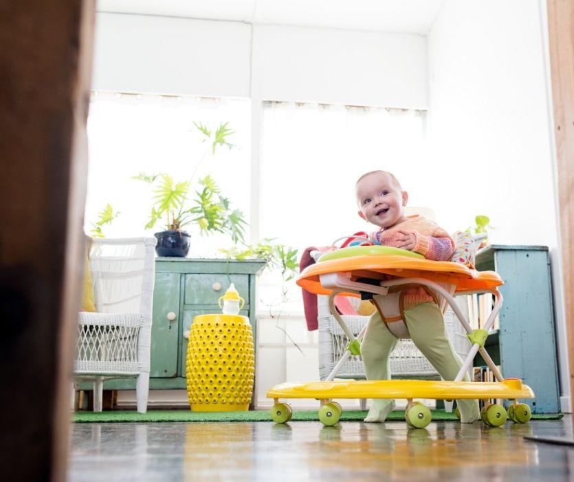 child at home in a baby walker