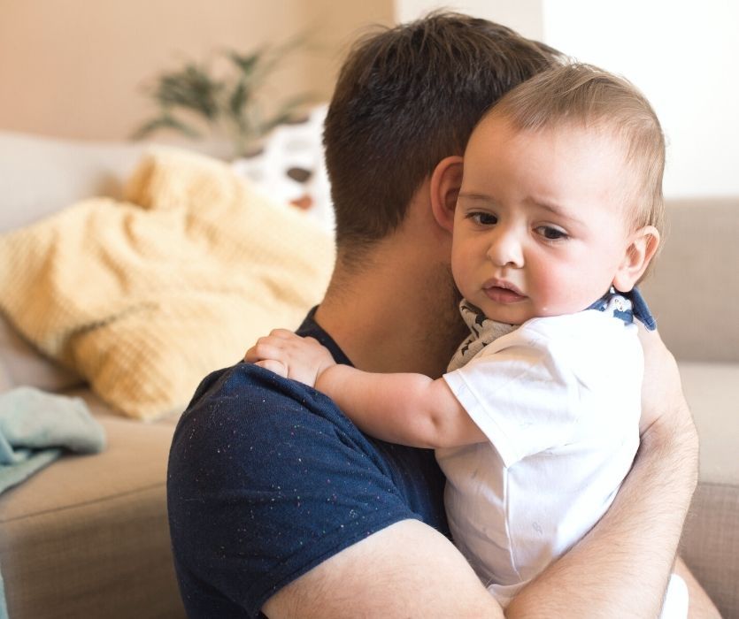 father holding his sick baby suffering with a cold