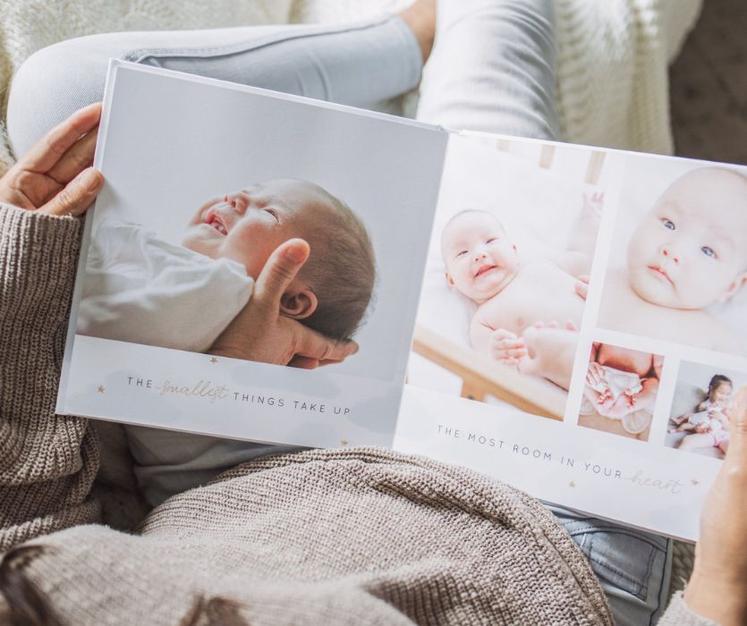 parent looking at a custom photo book of their baby