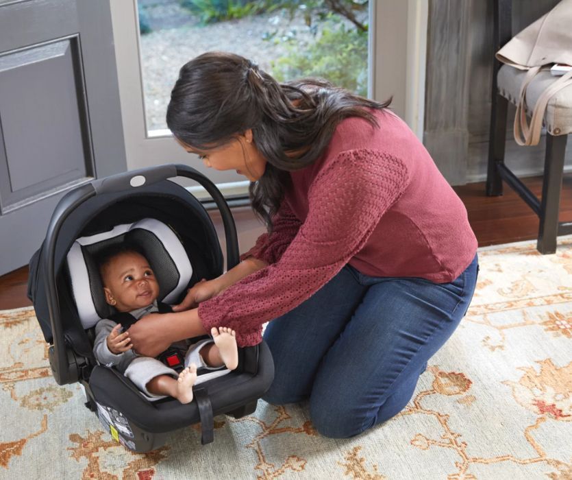 mom clipping her baby into an infant car seat