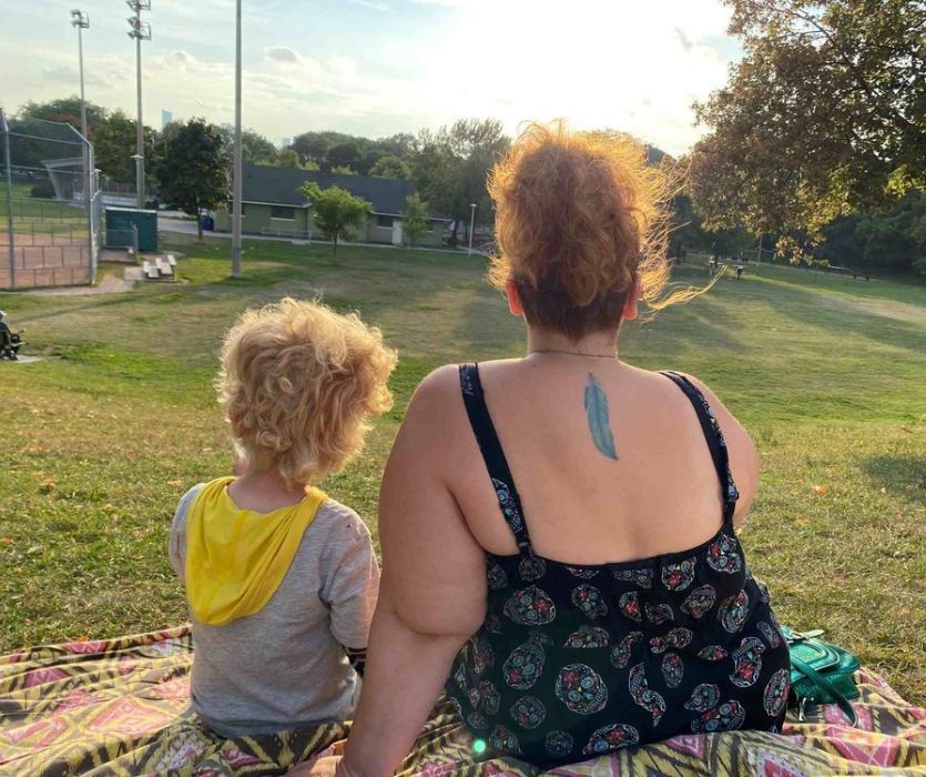 mother and son sitting of a picnic blanket in Greenwood park toronto