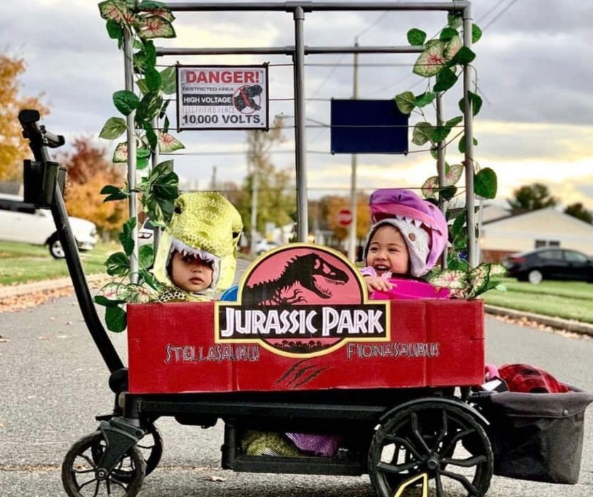 Two kids dressed as dinosaurs in Jurassic Park wagon halloween costume