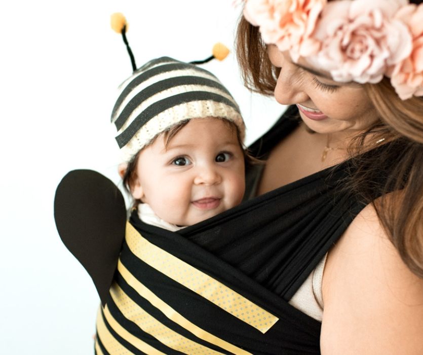mom holding baby in a carrier dressed up for halloween