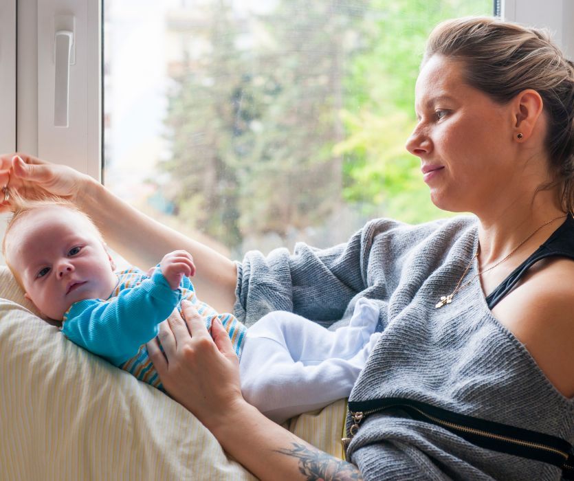 new mom suffering from postpartum anxiety holding her baby on her lap
