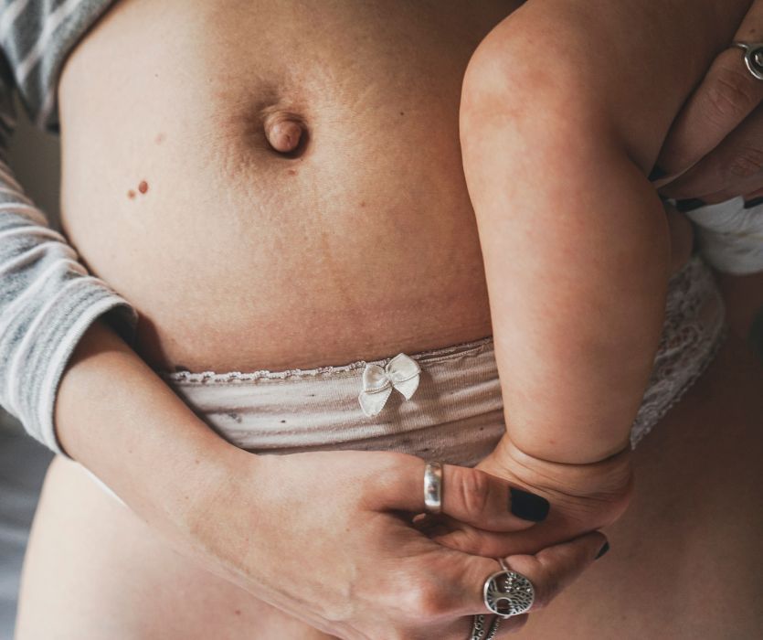 postpartum belly with mom holding baby
