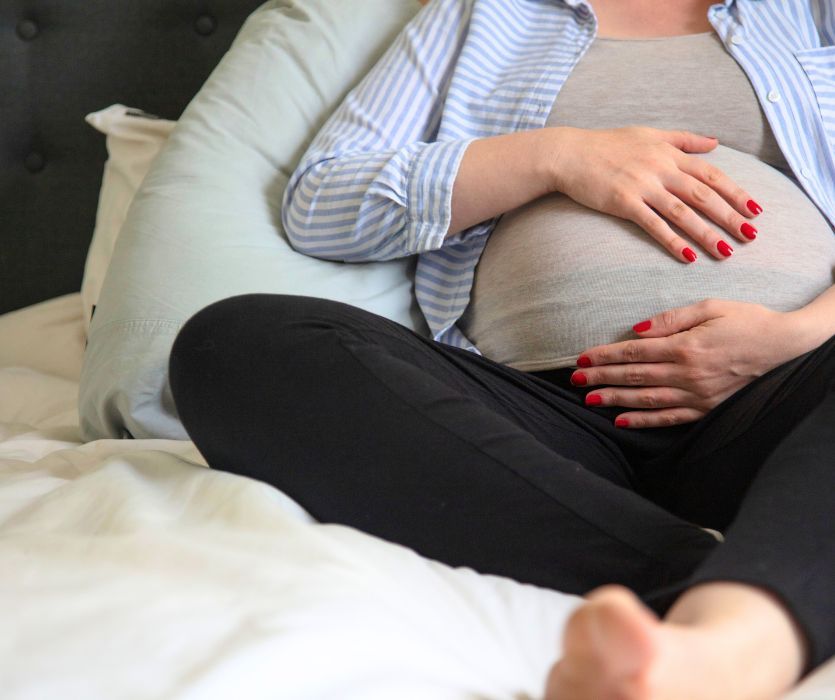pregnant woman resting on a bed
