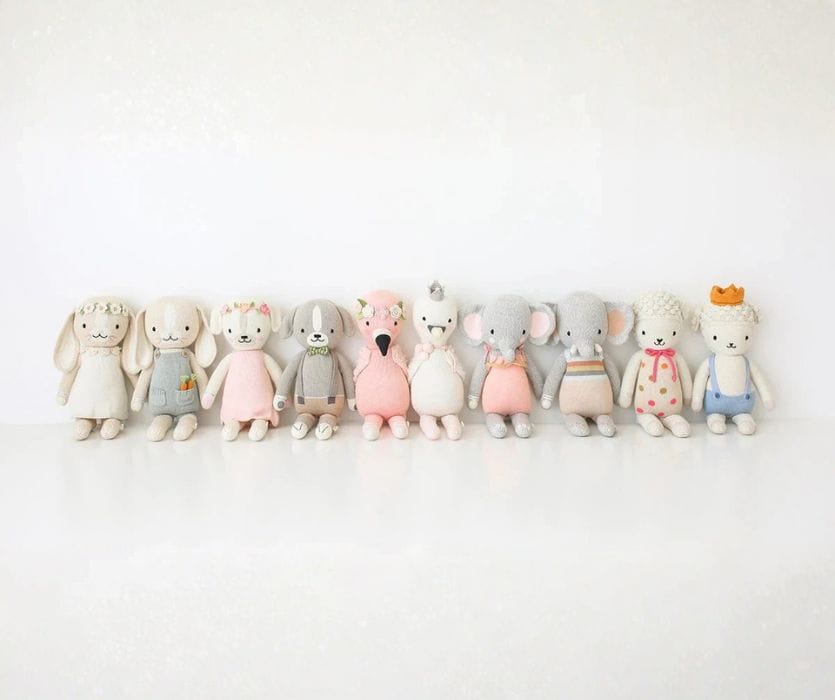 row of knitted dolls that give back to charities when you buy one for a baby gift