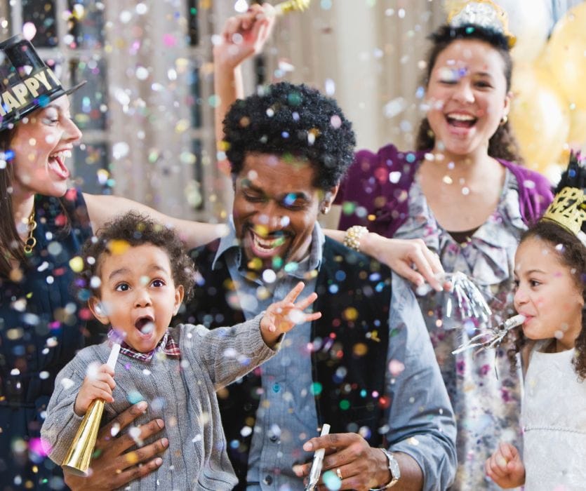 family celebrating new year's eve with young kids at noon