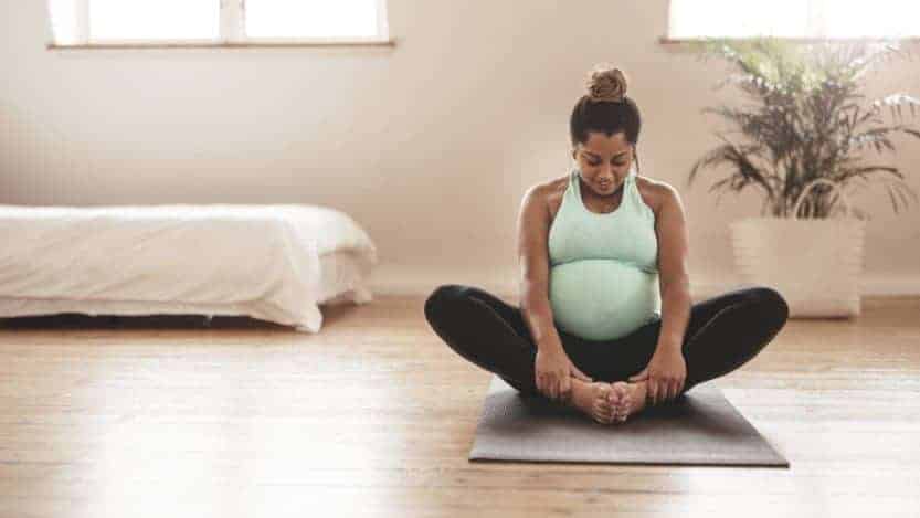 pregnant woman doing yoga in her home