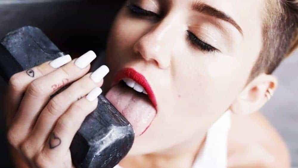Miley Cyrus licking the top of an sledgehammer to illustrate eating inappropriate things