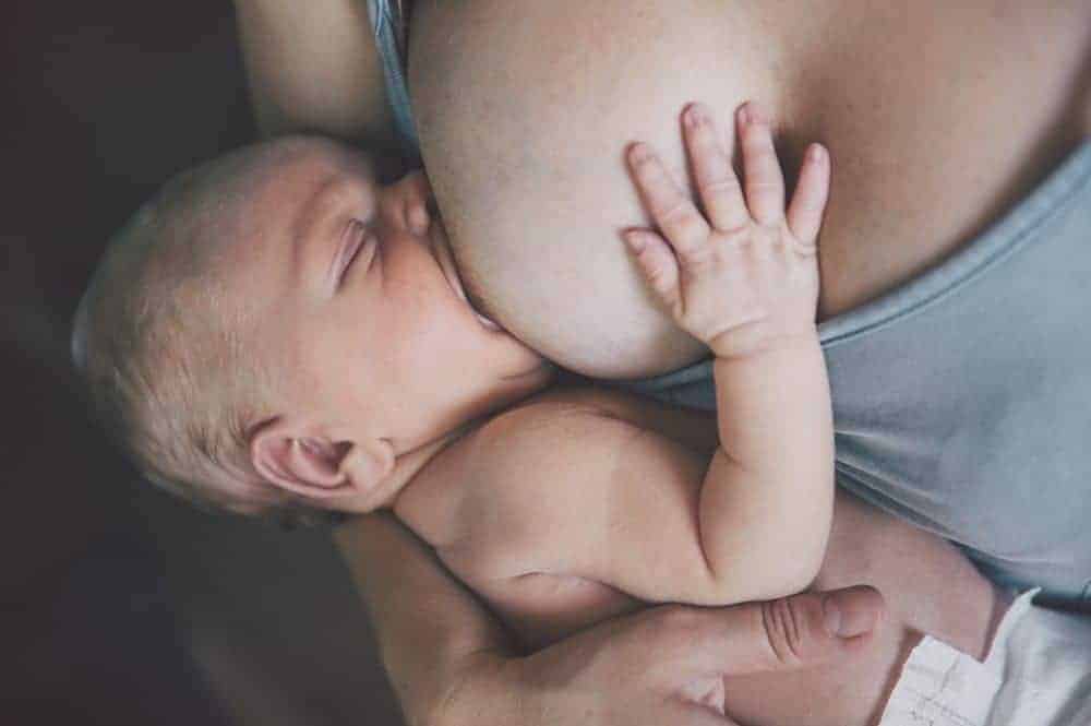 woman breast feeding a baby