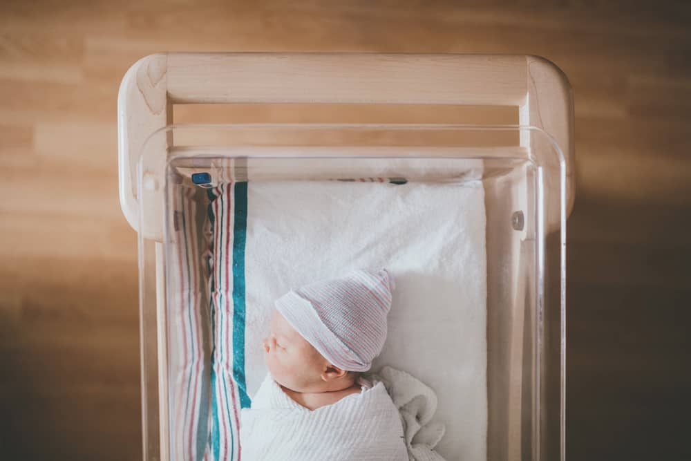 baby laying in hospital cot - how to conceive boy or girl