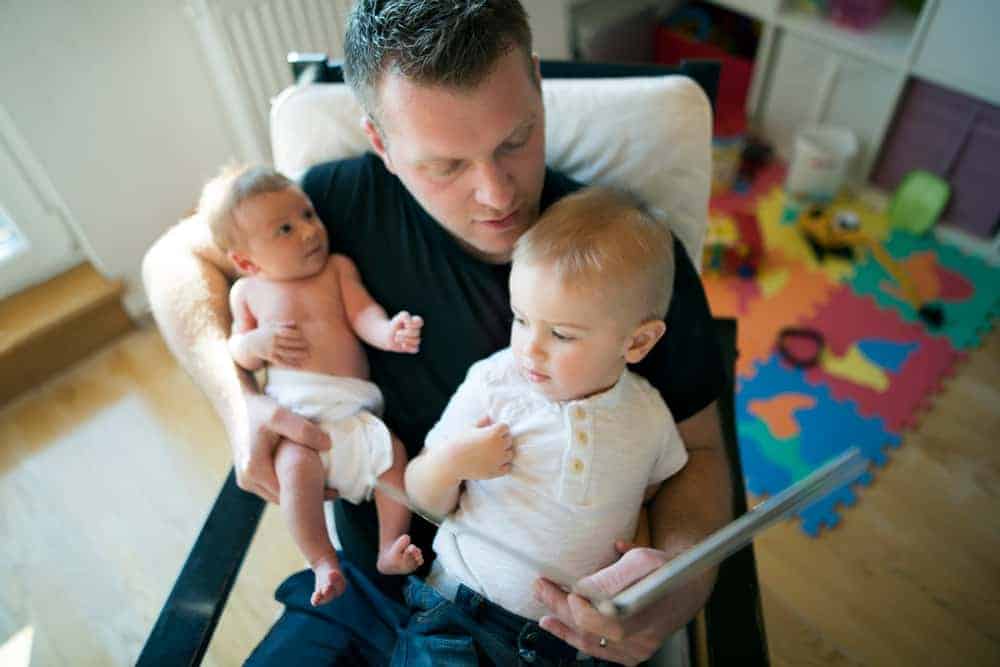 dad teaching kids about racism by reading to his baby and son