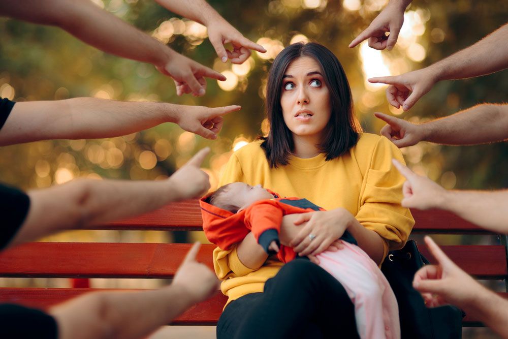 fingers pointing at new mom shaming her for her choices