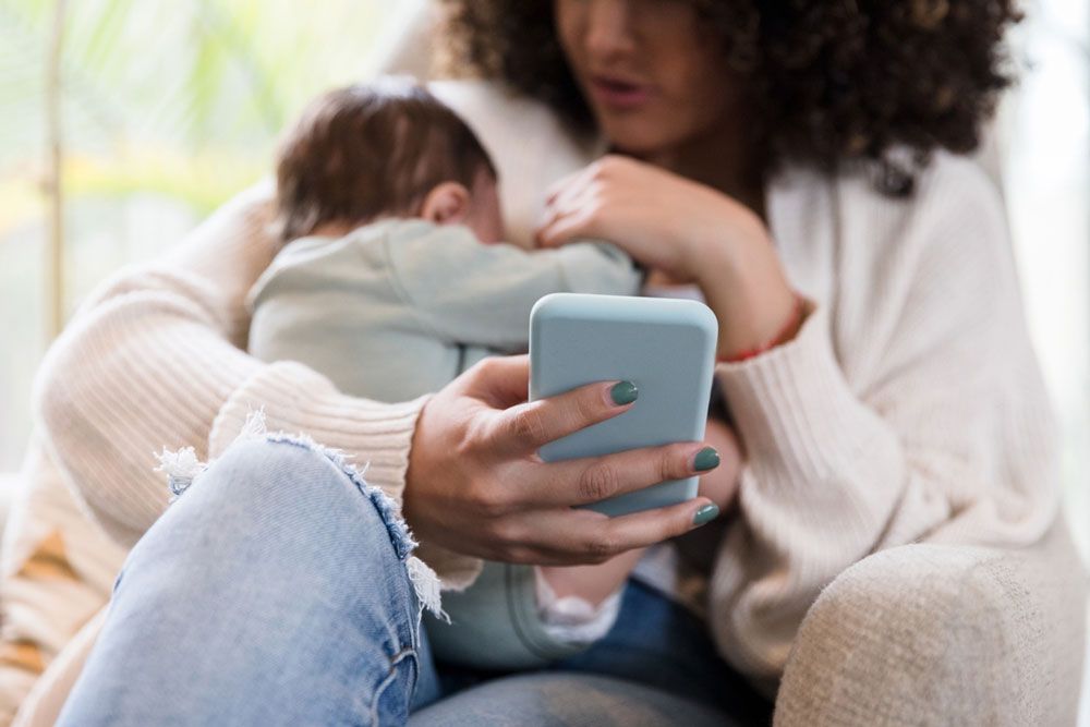 new mom looking up the right way to parent on her smart phone