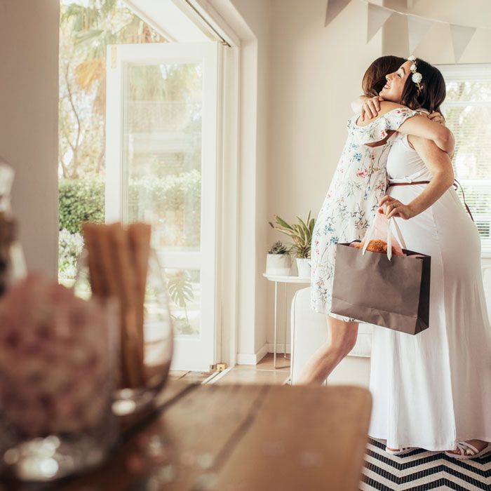 100 Unique Baby Shower Gift Ideas, pregnant woman being given a unique baby shower gift