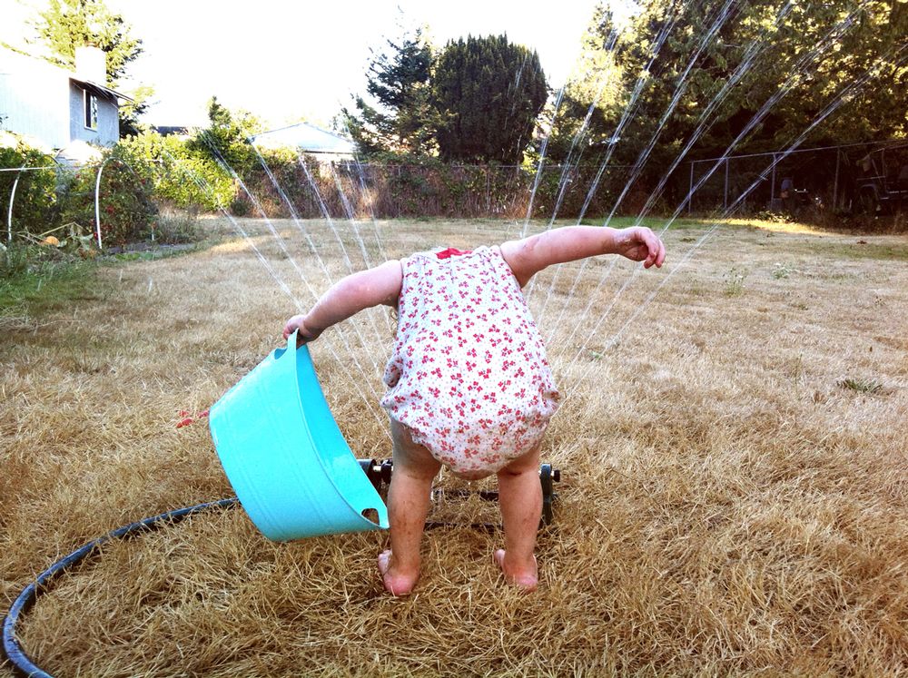 toddler in sprinkler proving that kids these days are just as bad (or good) as previous generations